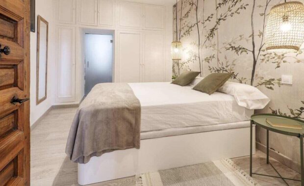 bedroom with a double bed decorated with wallpaper