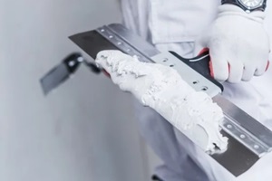 man applying drywall primer