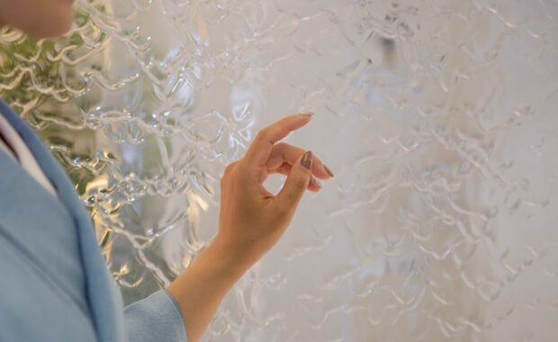 lady in blue kimono is praying in front of circulating water inside acrylic polycarbonate aqua wall panel in Japan