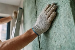 man installing a soundproof panel